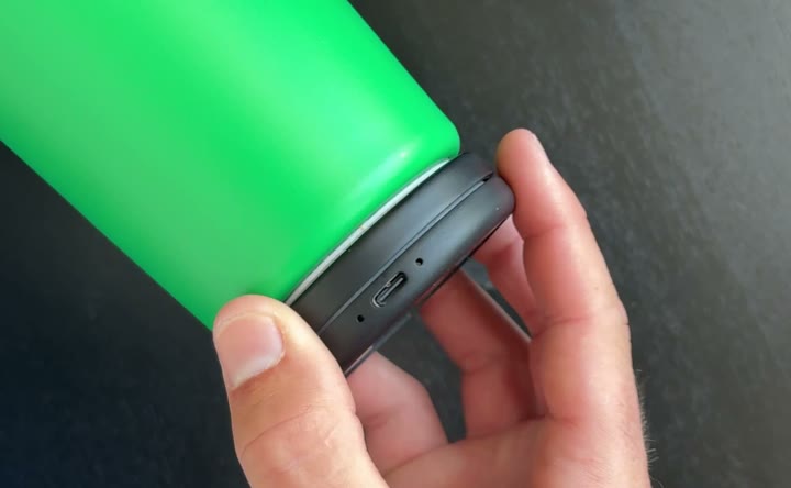 A hand holding a water bottle on its side with the Sponge Clip attached to its base, USB-C port visible
